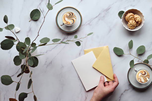 istock Greeting card mockup background. Mint green postal envelope, blank white card, pen and office stationary. Eucalyptus twigs on stone, overhead view, copy-space, place for text, lettering. 1460004150