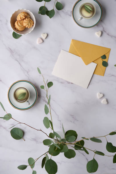 istock Greeting card mockup background. Mint green postal envelope, blank white card, pen and office stationary. Eucalyptus twigs on stone, overhead view, copy-space, place for text, lettering. 1460004162