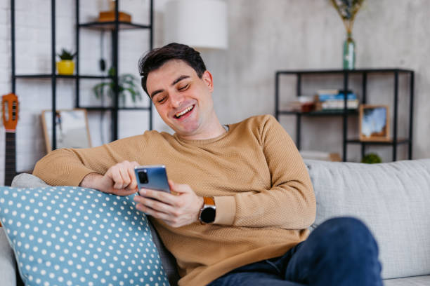 istock Young Man Texting On The Phone At Home 1460004265