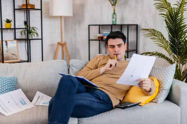 istock Young Man Checking His Finances At Home 1460005381