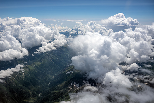 Aerial view of the valley in the mountains, flying over the clouds