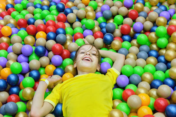 istock The girl child is having fun playing with colored balls. 1460006559