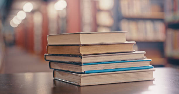 istock Library background, books on table and research, learning and studying in university, school or education. Reading, history and philosophy with vintage literature, language or knowledge book on desk 1460007177
