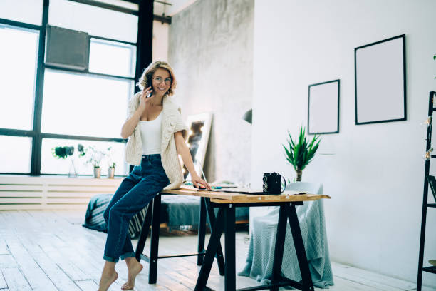 istock Gorgeous woman talking on phone while leaning on table 1460008919