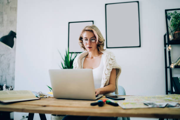 istock Amazed female browsing laptop at table at workplace 1460008944