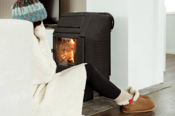 istock A woman sitting by a fireplace to warm up 1460009568