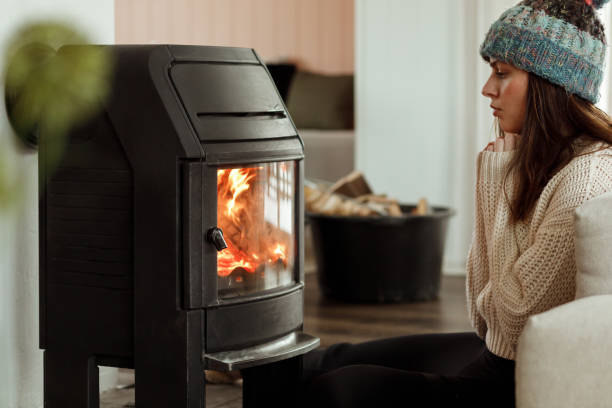 istock A woman sitting by a fireplace to warm up 1460009596
