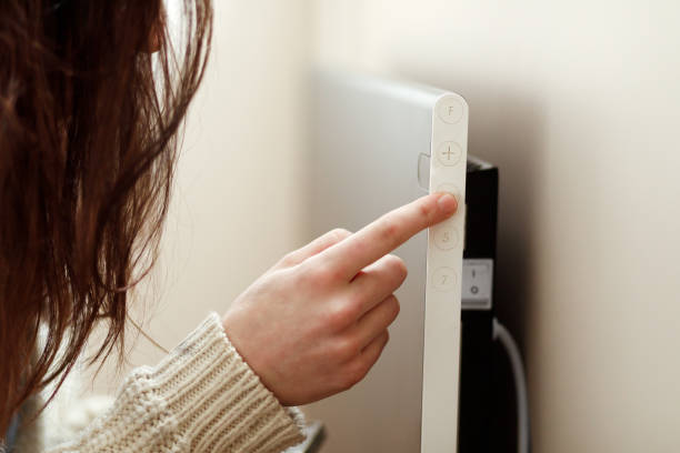 istock A hand setting the electric heater lower 1460009695