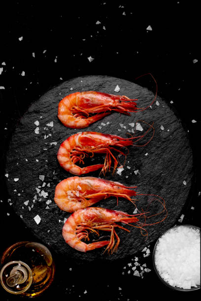 Prawns cooked with salt and oil on a stone plate vertical stock photo