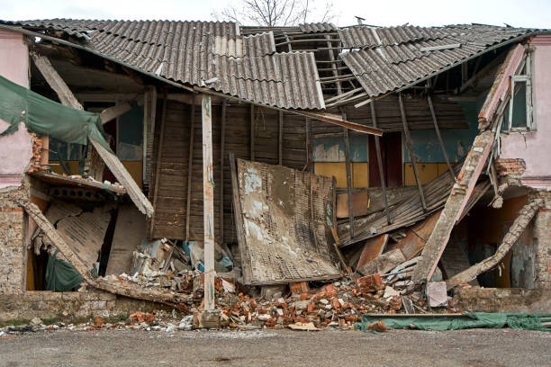 屋根が崩れた廃墟となった2階建ての建物 - bombing city earthquake disaster ストックフォトと画像