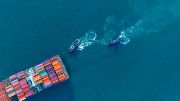 컨테이너를 운반하고 화물 야드 항구에서 맞춤형 해양 개념 기술 운송, 통관에 이르기까지 수입품을 위해 달리는 화물선의 선미가 있는 욕조 보트. 상위 뷰 - cruise ship business retail freight transportation 뉴스 사진 이미지