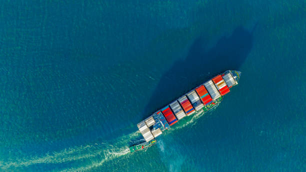 컨테이너를 운반하고 화물 야드 항구에서 맞춤형 해양 개념 기술 운송, 통관에 이르기까지 수입품을 위해 달리는 화물선의 선미가 있는 욕조 보트. 상위 뷰 - cruise ship business retail freight transportation 뉴스 사진 이미지