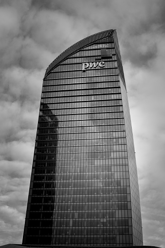 Milan, Italy - 2023, January 22 : One of the three towers of the new City Life business district of Milan called the Curved One or the PWC tower - monochrome