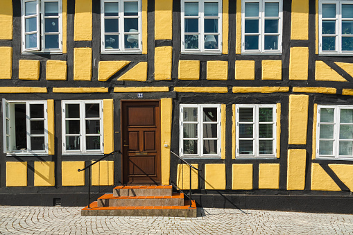 Façade of a very old, colourful building with partly wooden construction in Denmark