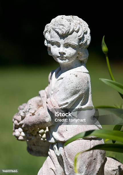 Estatua De Niño En Un Jardín Foto de stock y más banco de imágenes de Accesorio de jardín - Accesorio de jardín, Arte, Arte y artesanía