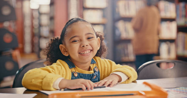 초상화를 입은 어린 소녀, 도서관에서 배우고 교육을 위해 미소와 행복으로 책을 읽는다. 공부하고, 배우고, 유치원생이 책, 학교와 성장과 지식으로 발전하는 것을 읽는다. - picture book library preschool bookshelf 뉴스 사진 이미지