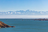 View of the Kapchagay reservoir with islands and a railway bridge against the backdrop of mountains in the Almaty region of Kazakhstan