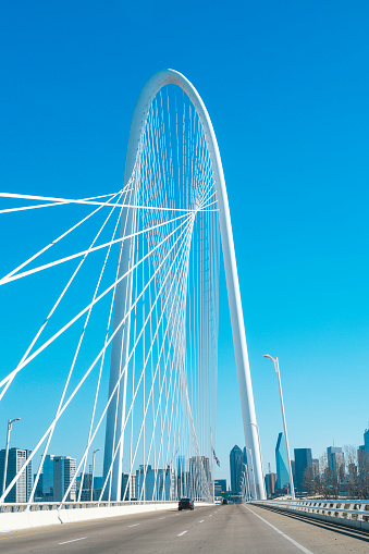 Margaret Hunt Hill Bridge with the clear blue sky and Dallas City downtown skyline in the background, cityscape from the highway over the Trinity River in Texas, USA