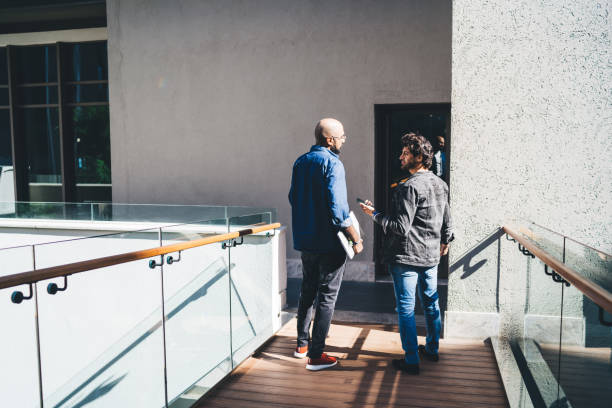istock Male colleagues discussing work before entering building 1460019286