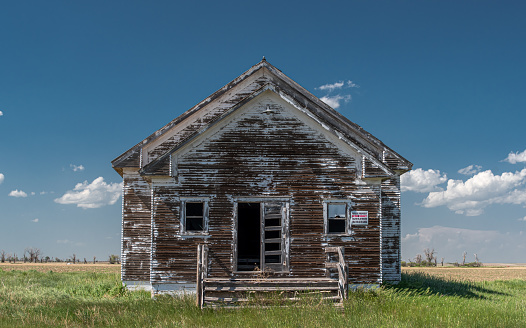 An abandoned and weathered school decaying on the western Nebraska prairie.