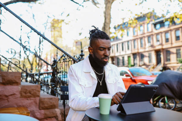 istock man sitting in a NY cafe, finishing work on a digital tablet 1460023855