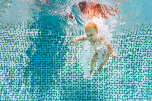 istock Happy child dive underwater with fun in swimming pool 1460024245