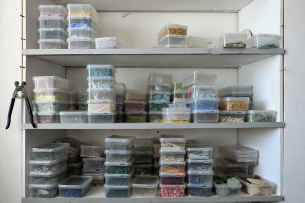 istock Plastic containers with smalt on shelves in closet. Regular or irregular pieces of colored stone or ceramic known as smalt for decorative art mosaic 1460025422