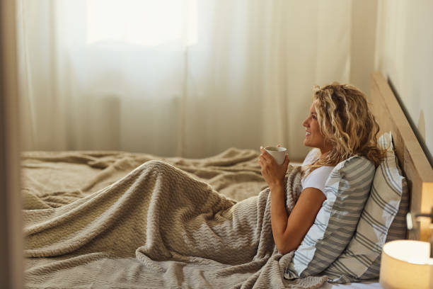 istock Happy woman day dreaming during coffee time in bed. 1460028199