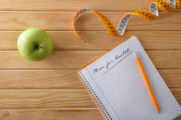 istock Health plan with apple notebook and tape measure top view 1460028522