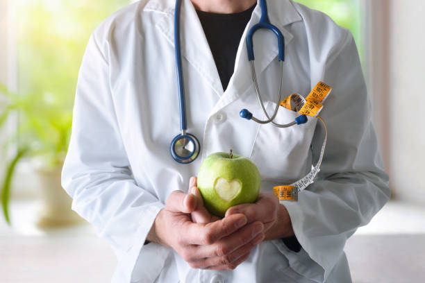 istock Doctor with apple dressed in gown equipped and window background 1460028537