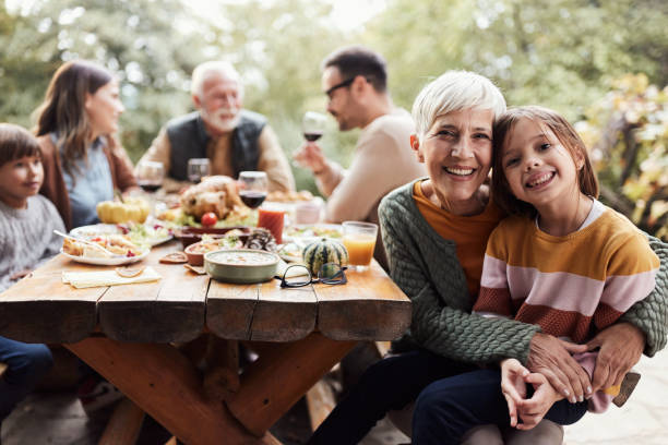 szczęśliwa babcia i wnuczka podczas rodzinnego obiadu na tarasie. - dining table child grandparent grandchild zdjęcia i obrazy z banku zdjęć