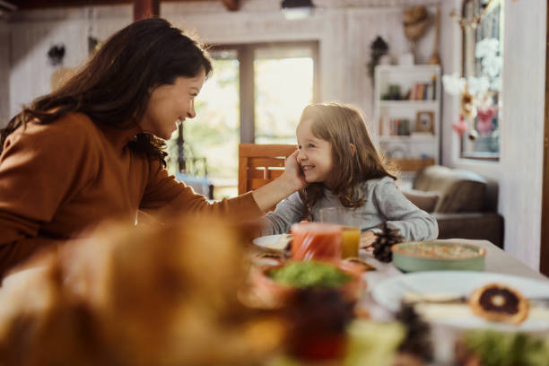 istock Loving mother and daughter talking during a meal at dining table. 1460030175
