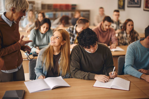 istock Happy female student talking to senior teacher on a class. 1460031766