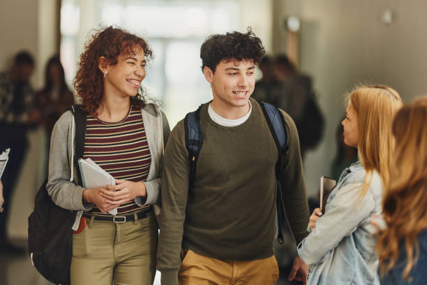 istock Happy students talking in a hallway of a school building. 1460031819