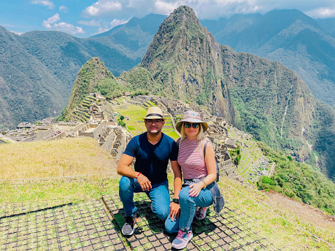 Young adult male and female couple on Machu Picchu travel famous destination, Peru