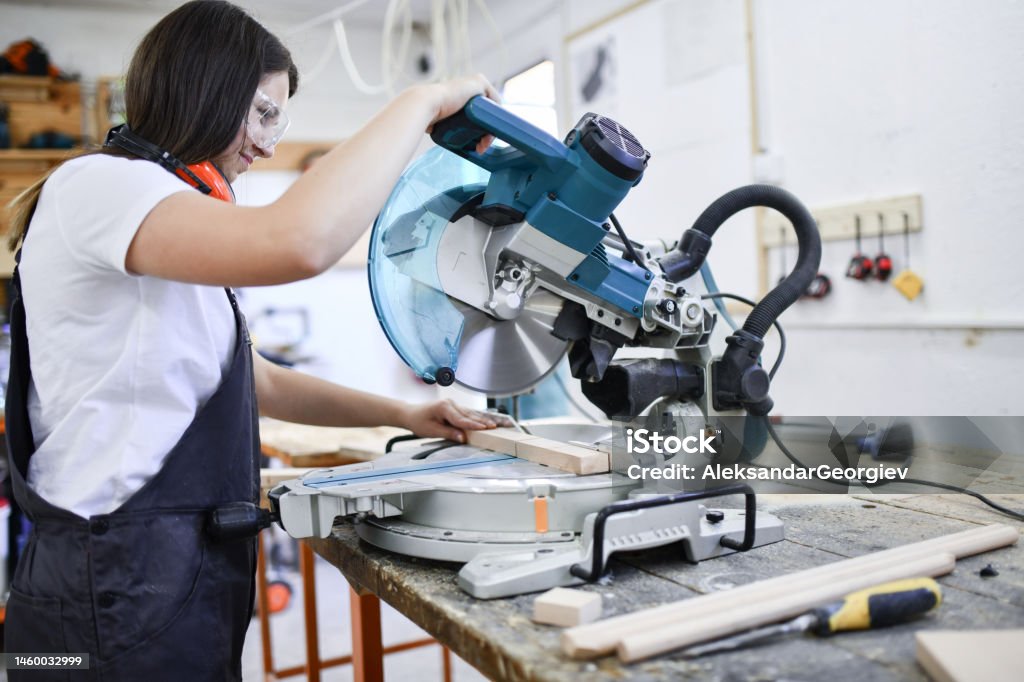 Female Carpenter Expertly Cutting Piece Of Wood Carpenter Stock Photo