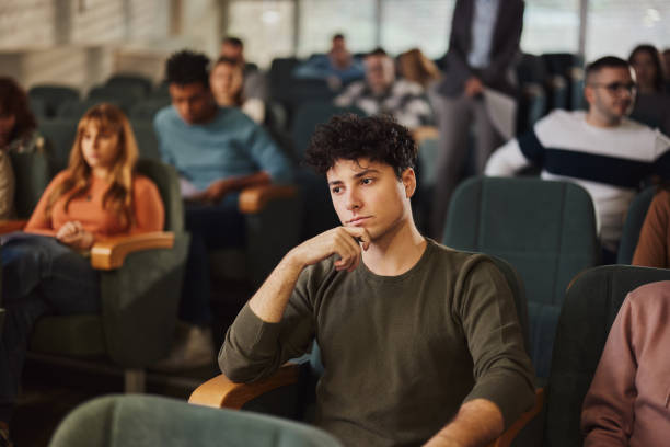 istock Pensive male student attending a class in a lecture hall at university. 1460033364