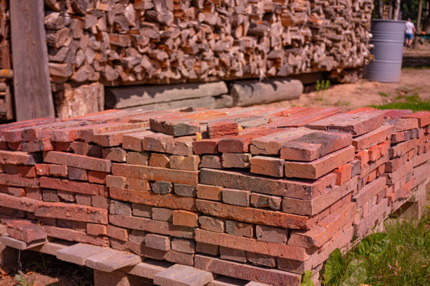 istock Red brick packed in stack are stored on ground outdoors at a hardware store warehouse. Building bricks on pallet on an outdoor warehouse 1460033682