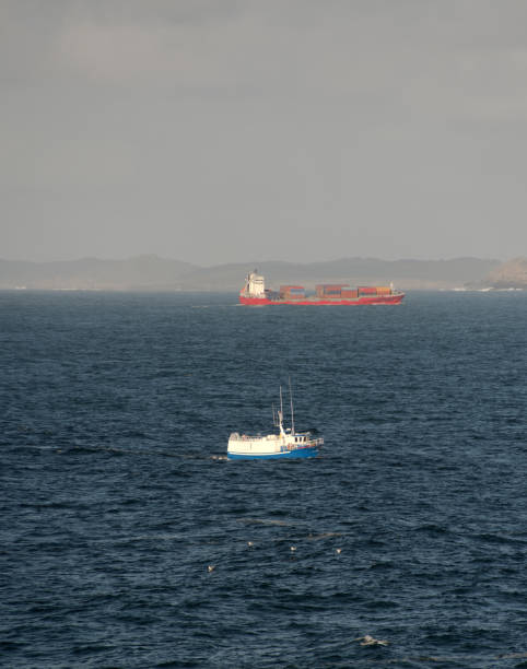 istock Cargo and fishing ships on a collision course in the blue sea 1460034071