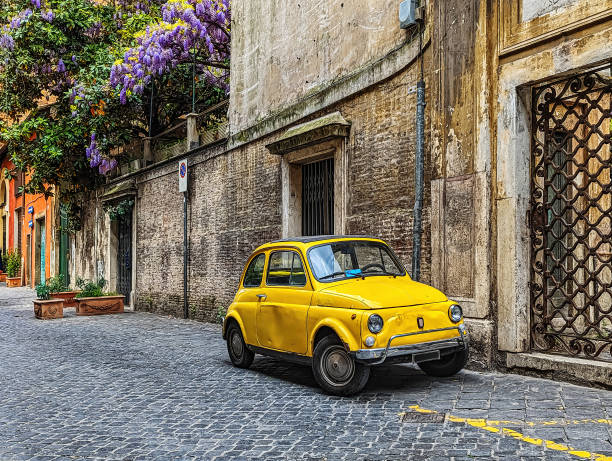 Small Yellow Car Parked on a Roman Street stock photo