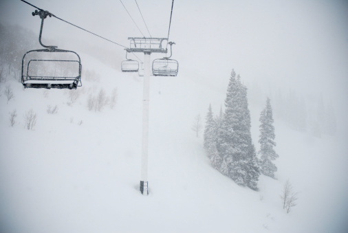 this is a photo  Of an empty chairlift during a little winter storm.  I really like how the chairs seem to vanish into the snowy distance.