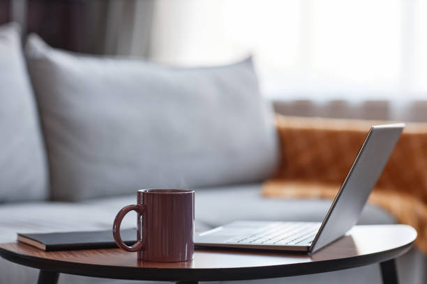 istock Coffee mug next to open laptop in cozy home 1460038631