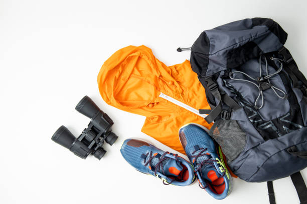 istock Binoculars, tourist backpack, raincoat, shoes on a white background. Top view, flat lay 1460038702