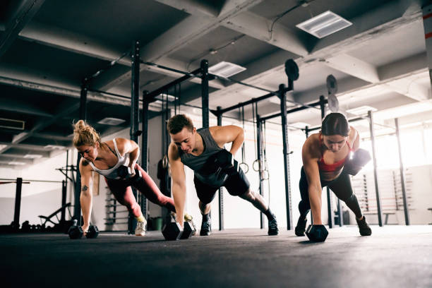 istock Athletes exercise together at the gym, with weights 1460040155