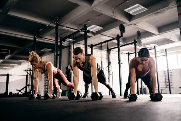 istock Athletes exercise together at the gym, with weights 1460040164