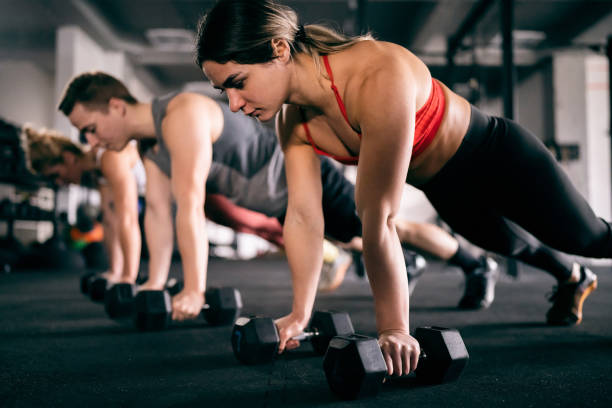 istock Athletes exercise together at the gym, with weights 1460040352