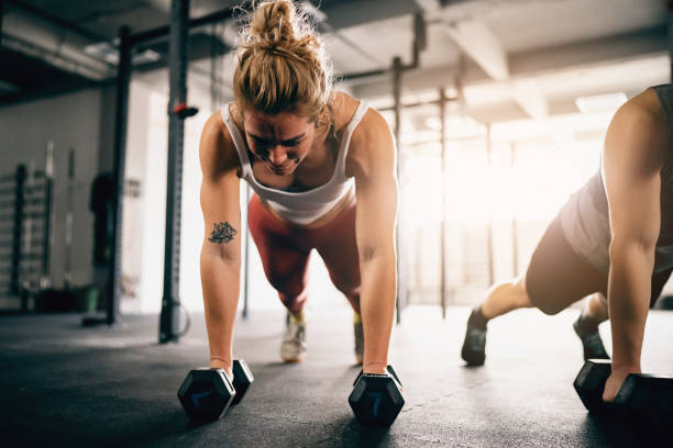 istock Athletes exercise together at the gym, with weights 1460040471