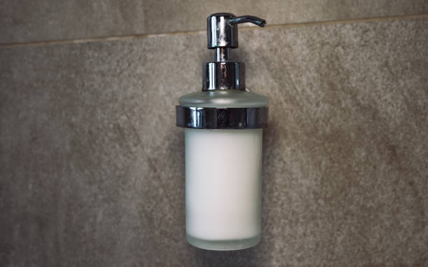 istock liquid soap isolated on bathroom wall. push-button liquid soap. close up of a silver push button 1460041100