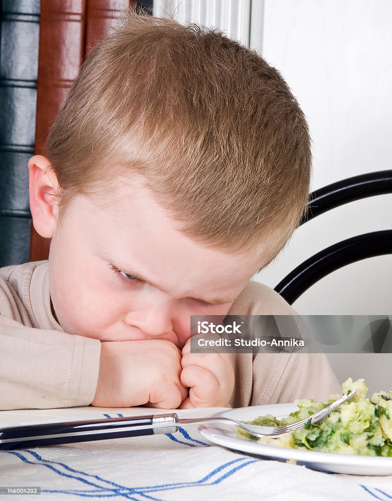 Veggies for dinner Four year old boy disliking the food on his plate Anger Stock Photo