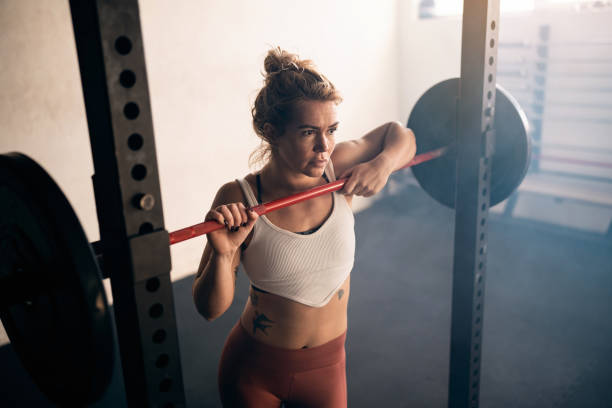 istock Woman leaning on the barbell, while resting during weight training in the gym 1460042407